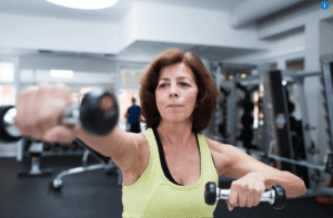 Woman exercising with dumbbells in gym